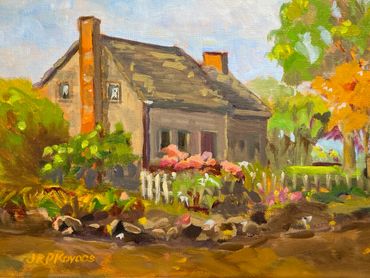 A charming house surrounded by colorful trees and flowers in an autumn setting.