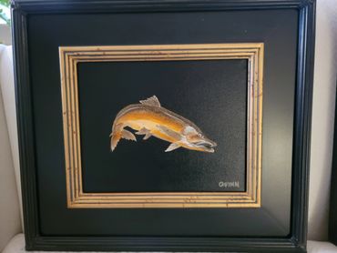 Framed artwork of a fish on a black background.