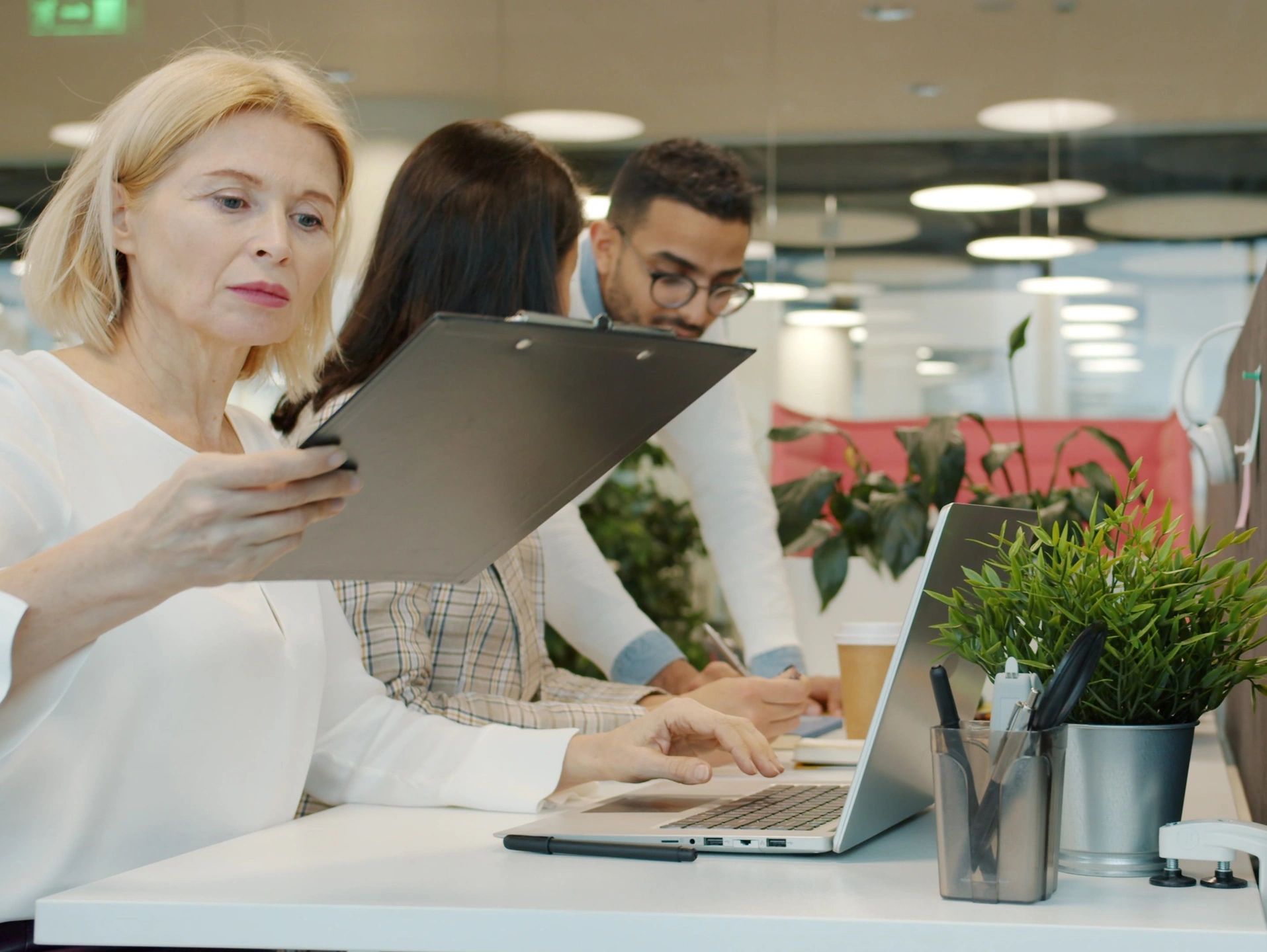 Mujer trabajando concentrada en oficina moderna.