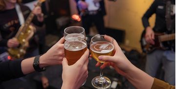 People toasting with drinks at a lively music event.