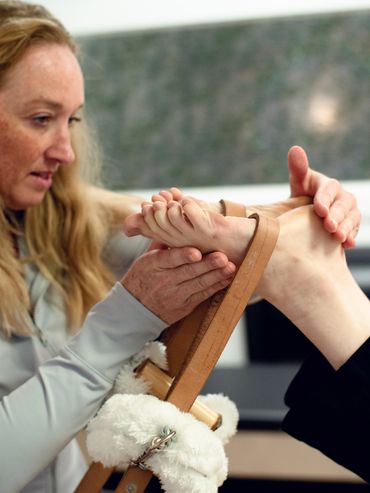 Hnads on assists with legs in straps