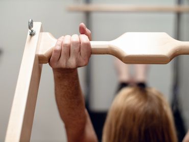 A woman doing a teaser with the push through bar