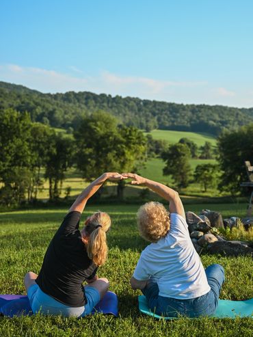 Two women practicing yoga outdoors