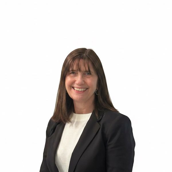 Smiling woman in business attire against white background.