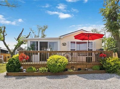 Single-story house with red umbrella on front deck.