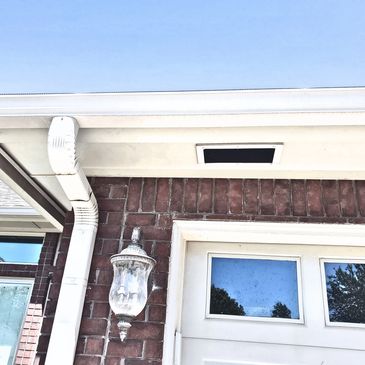 White Critter Tough animal proof soffit vent installed on a brick home.