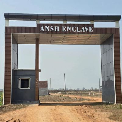 Entrance gate of Ansh Enclave on a dirt road.