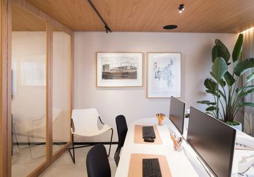 Modern office workspace with dual monitors and minimalist decor.