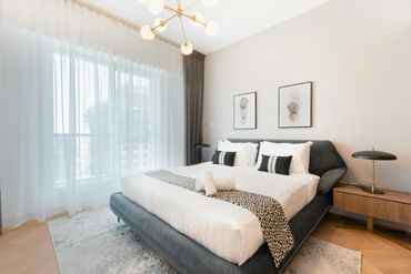 Modern bedroom with large window and minimalistic decor.