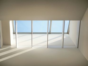 Modern skylight casting geometric shadows on a white ceiling.