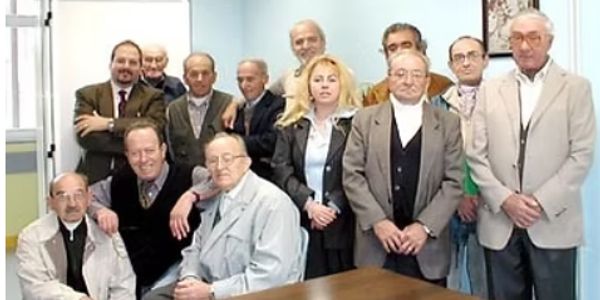 Group of elderly people posing indoors for a photo.
