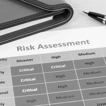 Close-up of a risk assessment document with a pen and folder on a desk.