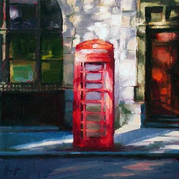 An English telephonbooth in front of a sunlit facade
