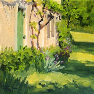 Sunny garden scene with flowers and vines on a wall.