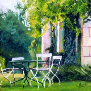 Gardentable with chairs in front of facade with greenery