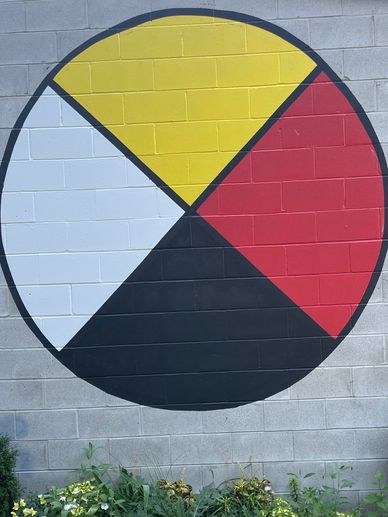 A circular mural divided into four colored quadrants on a tiled surface.