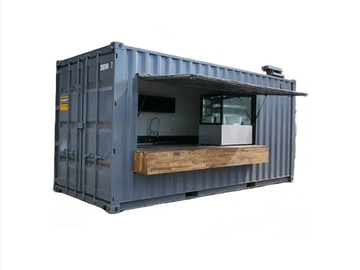 A converted shipping container with a serving window and wooden counter.