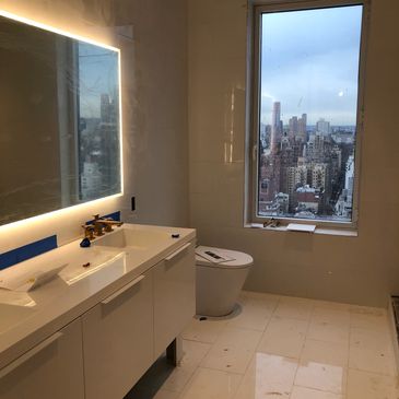 Modern bathroom with city skyline view through large window.