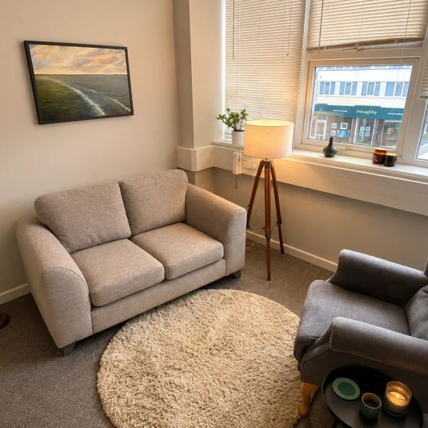 Cozy living room with a loveseat, armchair, and floor lamp.