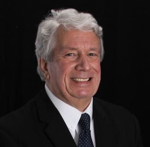 Smiling elderly man in suit and tie.