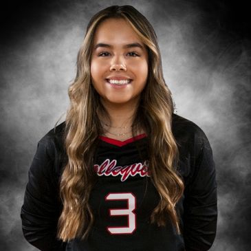 Young female athlete in volleyball uniform smiling.