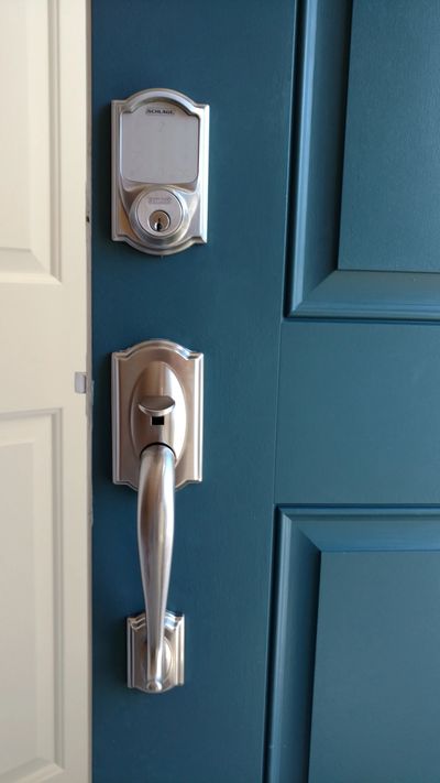 Satin nickel electronic deadbolt and handle on blue door.
