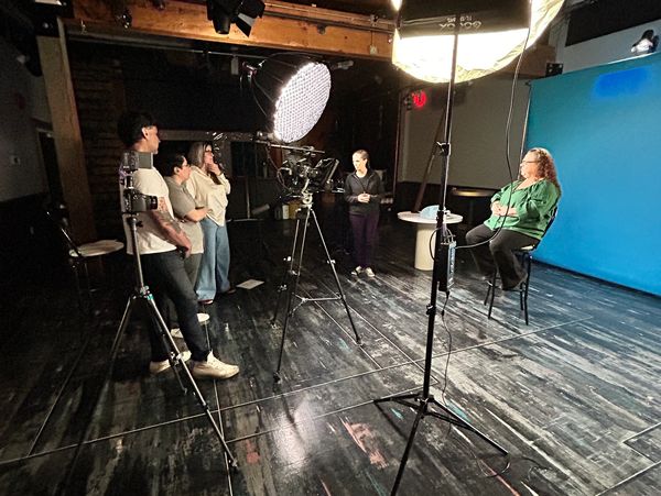 Producer an directors having an on-set conversation with an ASL user who is post-menopausal