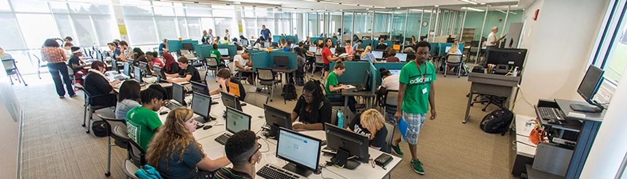 Busy computer lab with students working on desktop computers.