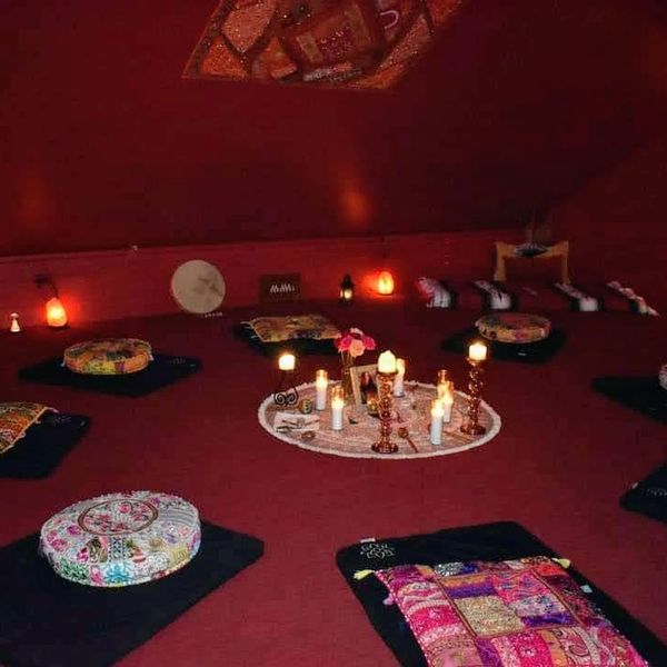 Cozy meditation room with cushions and candles.