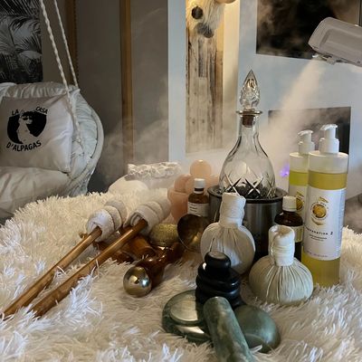 A cozy spa setup with massage tools and oils on a fluffy surface.
