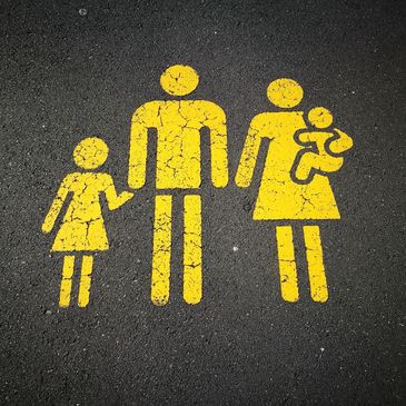 Gelbe Familiensymbole auf Asphalt gemalt.