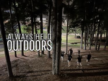 Group of people running through a wooded area at night with the text 'Always Held Outdoors'.