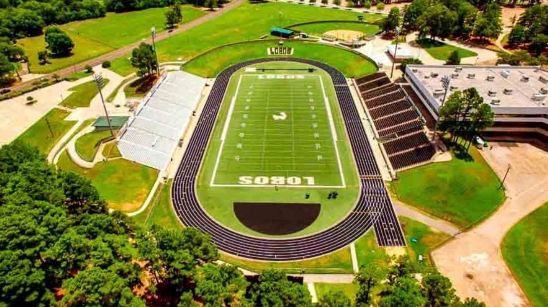 Aerial view of a Lobos football field with a surrounding track and bleachers.