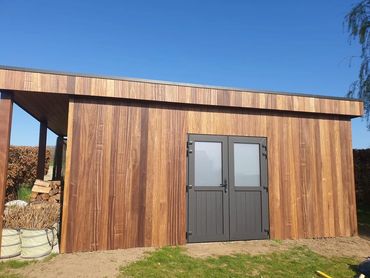 Tuinhuis met padouk gevel en dubbele deur, ramen door James Baekeland geplaatst