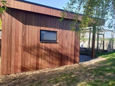 Afgewerkt tuinhuis met padouk en stijlvol raam, strak in elke hoek