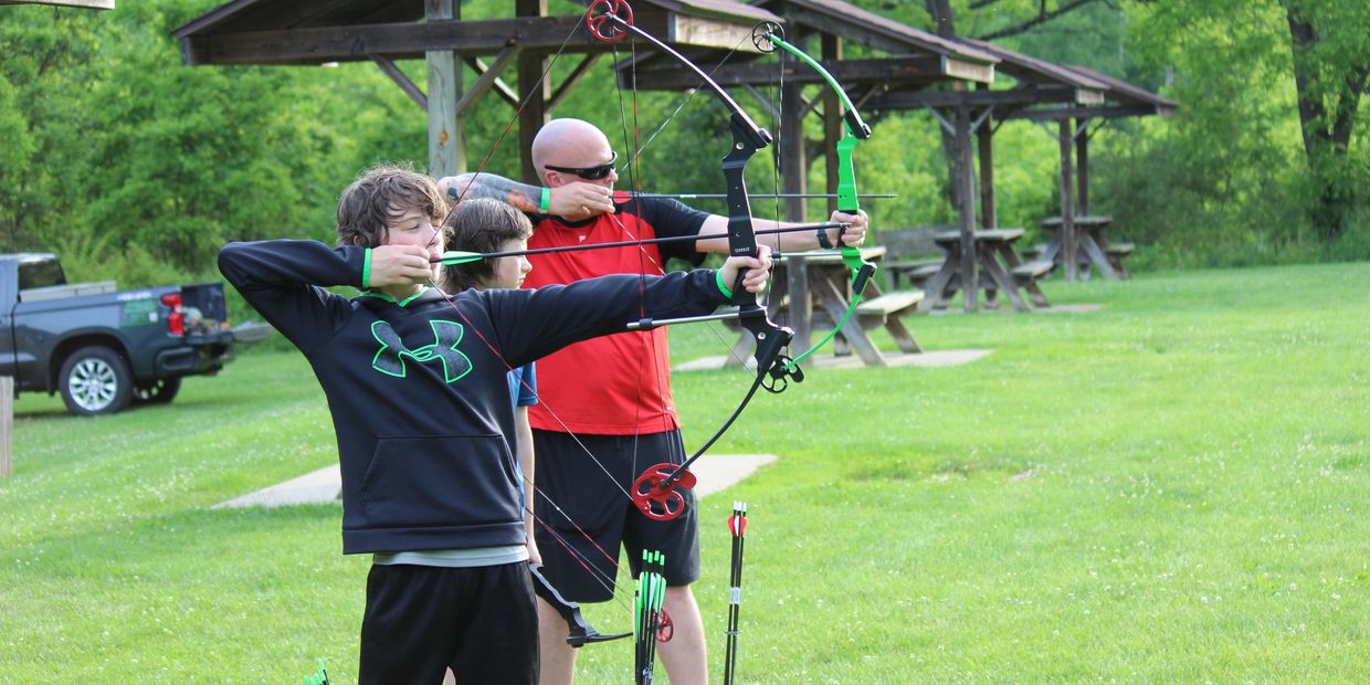 Family shooting bow and arrow in the hocking hills