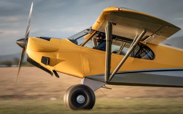 Yellow small aircraft with pilot ready for takeoff.