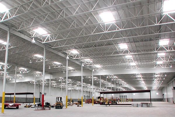 Spacious industrial warehouse interior with high ceilings, bright lights