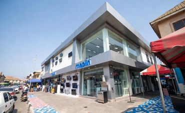 Modern electronics store on a sunny street corner.