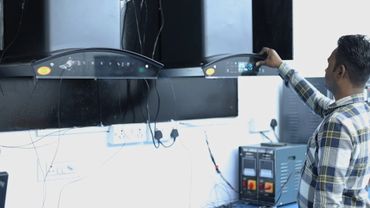 Man adjusting settings on electronic equipment in a lab.