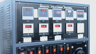 Close-up of an electronic multi-testing panel with digital meters and switches.