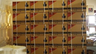 Stacked cardboard boxes labeled 'Kitchen Chimney' in a storage area.