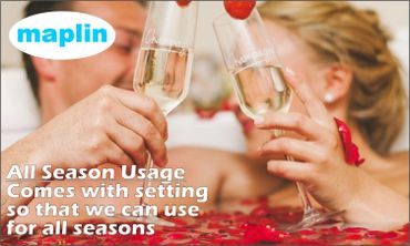 Couple toasting with champagne glasses in a romantic setting with rose petals.