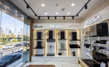 Modern kitchen appliances displayed in a bright showroom with large windows.
