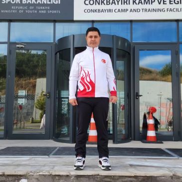 Bir adam spor kıyafeti ile dışarıda duruyor.