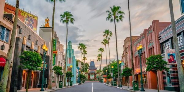 Palm-lined street with Art Deco buildings and sunset sky.
