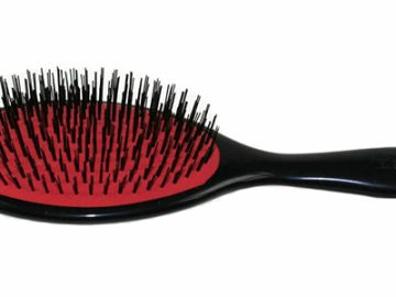 Black hairbrush with red base and plastic bristles.
