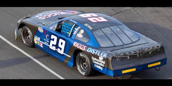 Blue and black race car with number 29 on a race track.