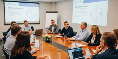 Business meeting with professionals discussing QMS implementation in a conference room.