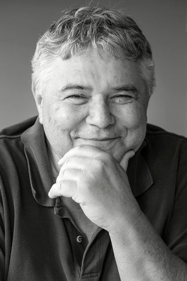 Portrait of a smiling elderly man in black and white.